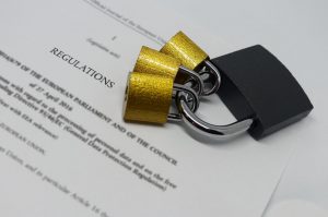 Closeup of padlocks laid out on document containing GDPR legislative text.